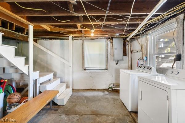 basement featuring separate washer and dryer, stairs, and electric panel