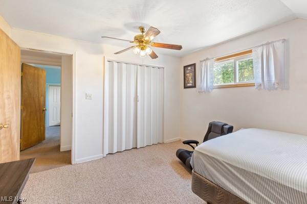 carpeted bedroom with baseboards, ceiling fan, and a closet