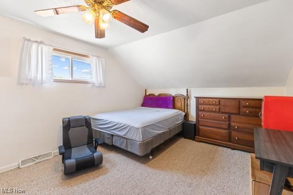 carpeted bedroom featuring visible vents, baseboards, ceiling fan, and lofted ceiling
