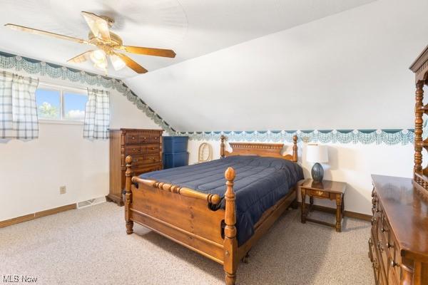 bedroom with baseboards, vaulted ceiling, and carpet flooring