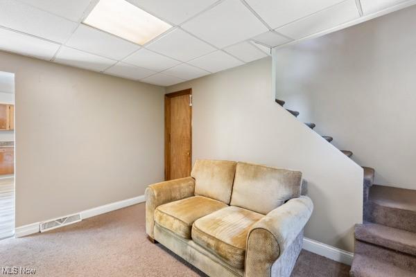 sitting room featuring visible vents, baseboards, carpet floors, and stairway