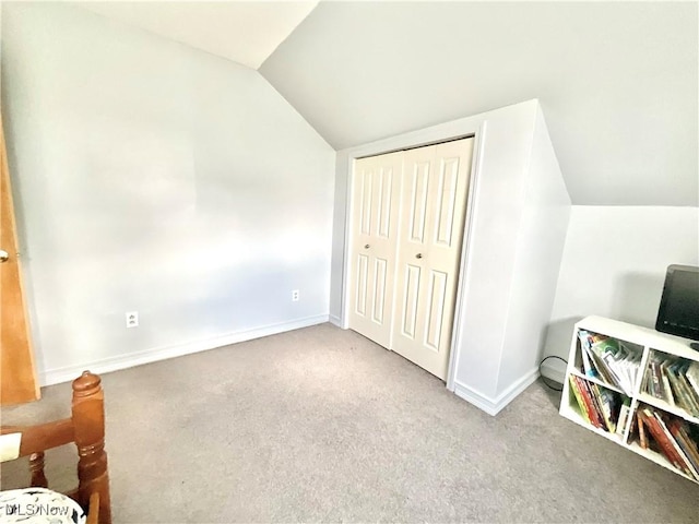 carpeted bedroom with baseboards, vaulted ceiling, and a closet