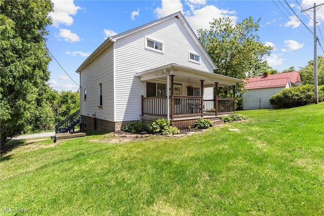 back of house with a lawn and covered porch
