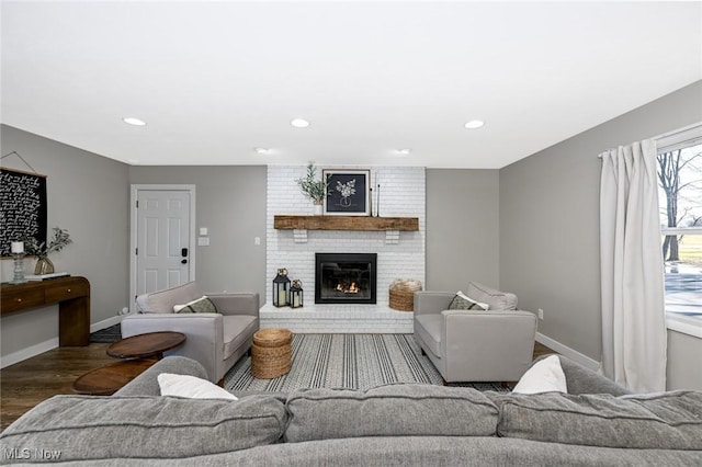 living room featuring a brick fireplace, recessed lighting, wood finished floors, and baseboards