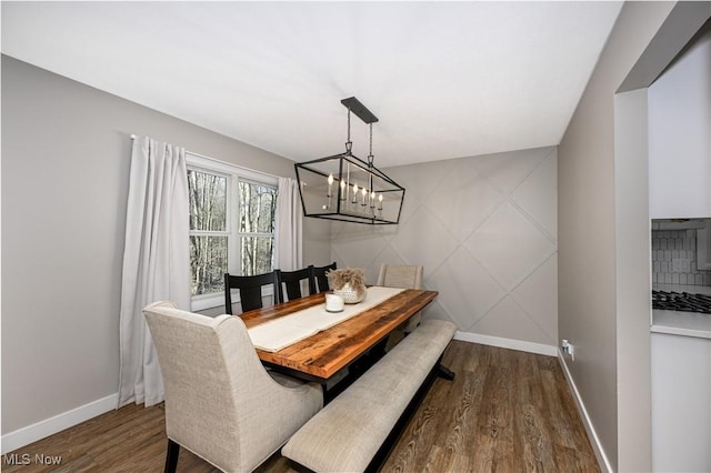 dining area featuring a chandelier, baseboards, and dark wood-style flooring