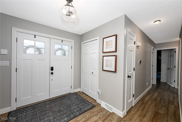 entryway featuring visible vents, wood finished floors, and baseboards