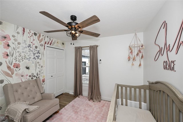 bedroom with baseboards, a textured ceiling, ceiling fan, and wood finished floors