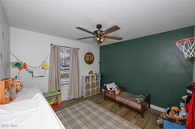 bedroom with ceiling fan, a textured ceiling, and wood finished floors