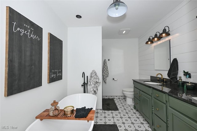 bathroom with toilet, a freestanding bath, and vanity