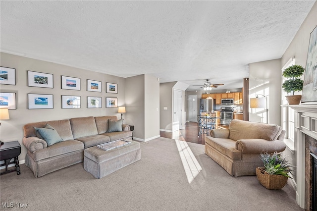 living room with baseboards, a fireplace, light colored carpet, and a textured ceiling