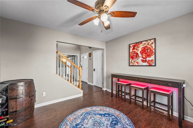 interior space featuring stairs, wood finished floors, baseboards, and a ceiling fan