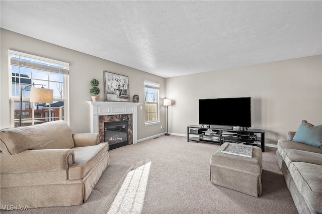 carpeted living room with baseboards, a textured ceiling, and a high end fireplace