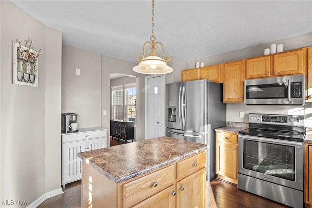 kitchen featuring dark wood-type flooring, decorative light fixtures, appliances with stainless steel finishes, and a center island