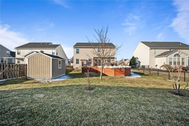 rear view of house with a fenced backyard, a storage shed, an outdoor structure, and a lawn