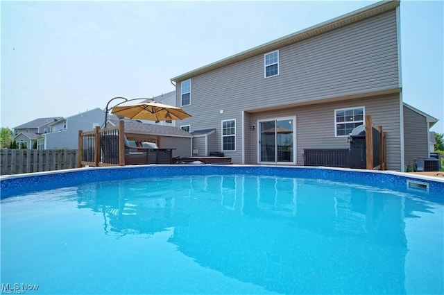 view of pool with a fenced in pool, fence, central AC, and grilling area