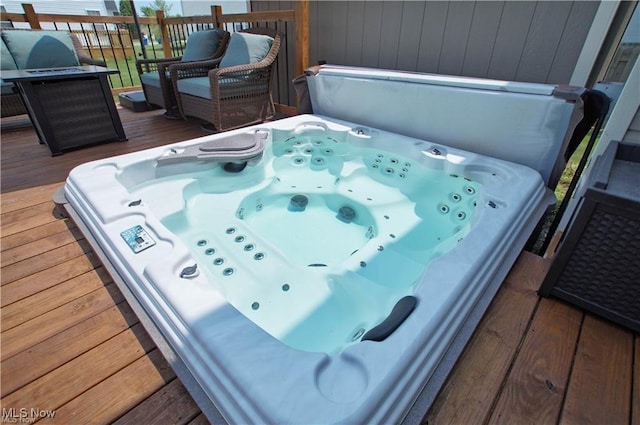 wooden terrace featuring hot tub deck surround