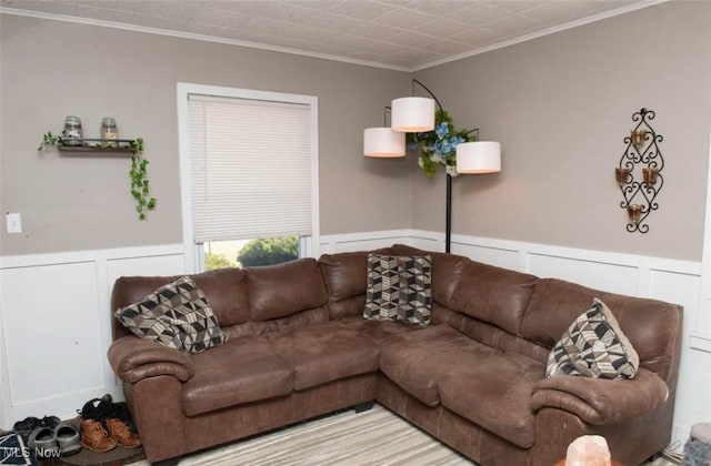 living area featuring a wainscoted wall and ornamental molding