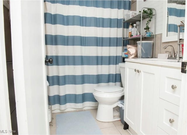 bathroom featuring tile patterned flooring, curtained shower, toilet, and vanity