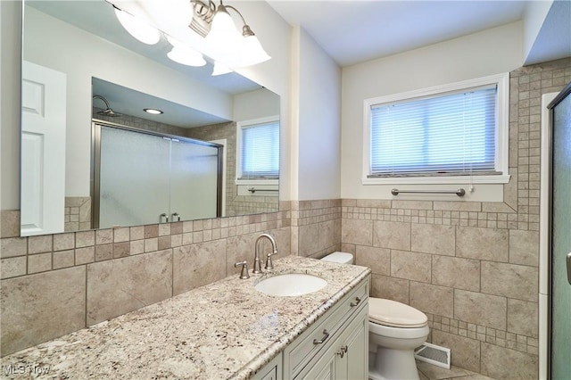 bathroom with visible vents, a stall shower, toilet, and vanity