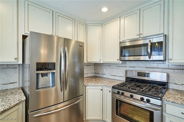 kitchen featuring tasteful backsplash, recessed lighting, appliances with stainless steel finishes, and light stone counters