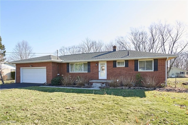 single story home with aphalt driveway, an attached garage, brick siding, and a front lawn