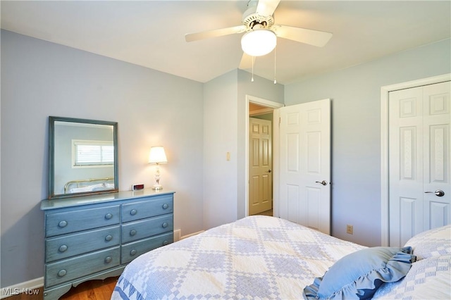 bedroom featuring ceiling fan, a closet, and dark wood-style floors