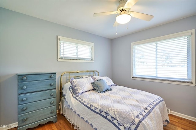 bedroom with a ceiling fan, baseboards, and wood finished floors