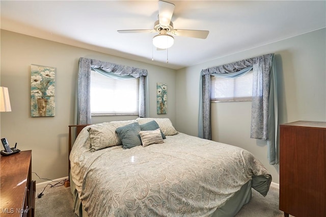 carpeted bedroom with baseboards, multiple windows, and ceiling fan