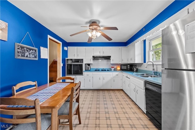 kitchen with black appliances, a sink, under cabinet range hood, white cabinets, and light floors