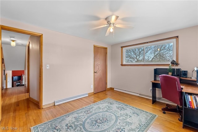 office featuring baseboards, baseboard heating, light wood-style flooring, and a ceiling fan