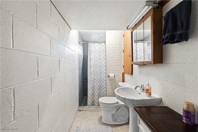 bathroom featuring curtained shower, a textured ceiling, toilet, and a sink