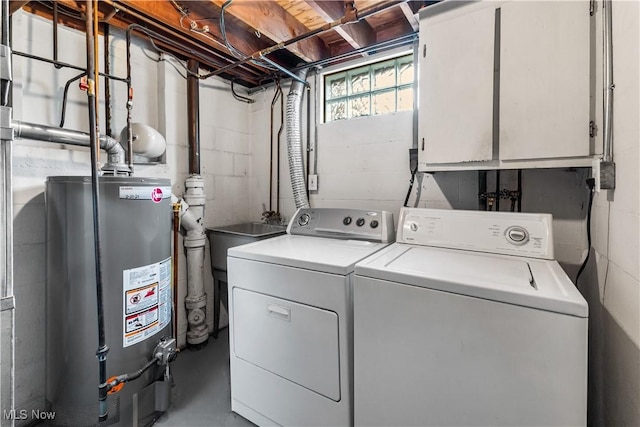 washroom featuring gas water heater, cabinet space, and washer and clothes dryer