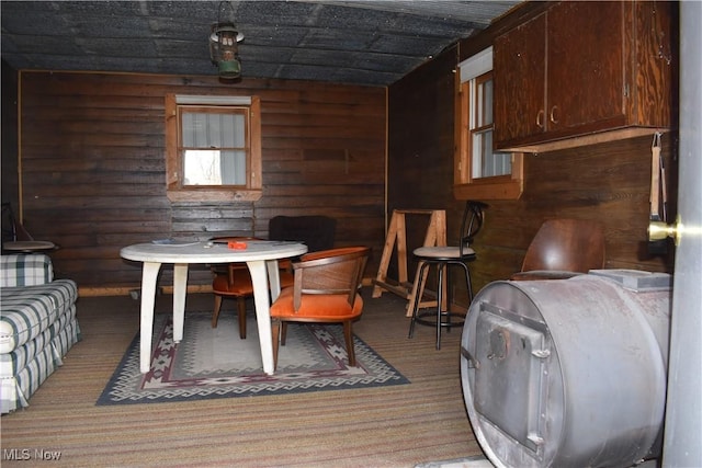 carpeted dining area featuring log walls