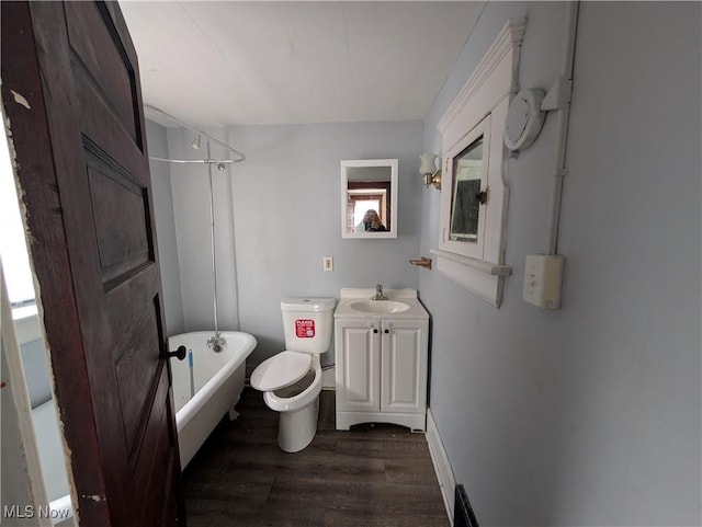 full bathroom featuring toilet, a washtub, wood finished floors, walk in shower, and vanity