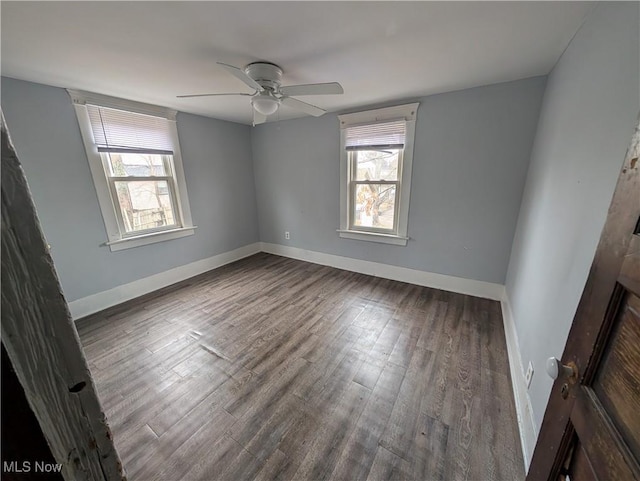 empty room featuring a ceiling fan, baseboards, and wood finished floors