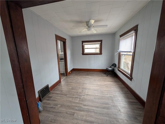 unfurnished room featuring visible vents, a ceiling fan, baseboards, and wood finished floors