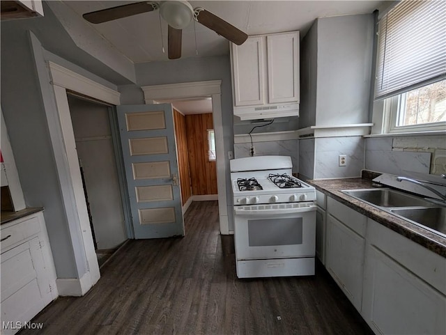 kitchen featuring dark wood-style floors, a sink, white cabinets, under cabinet range hood, and white gas range