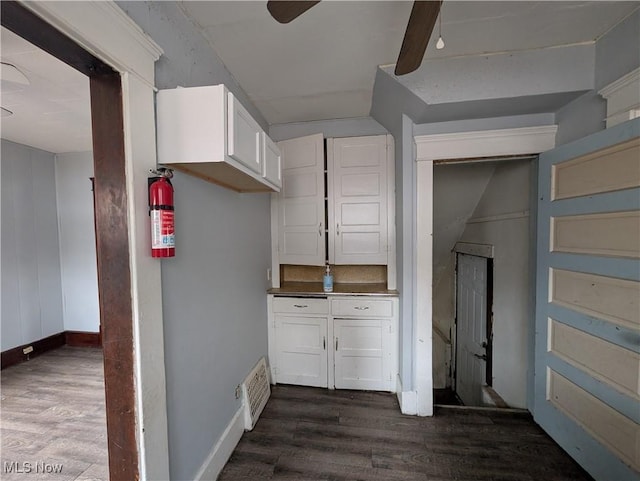 kitchen featuring visible vents, dark wood-style floors, white cabinetry, baseboards, and ceiling fan