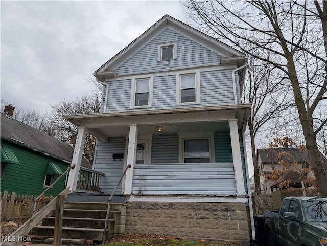 view of front facade featuring a porch and fence