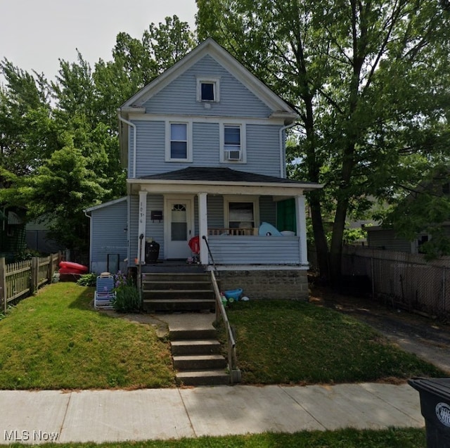 view of front of property featuring a porch, a front lawn, and fence