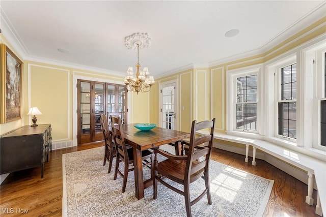 3006 Kingsley Rd, Shaker Heights, OH 44122 - dining area featuring visible vents, a notable chandelier, wood finished floors, and crown molding