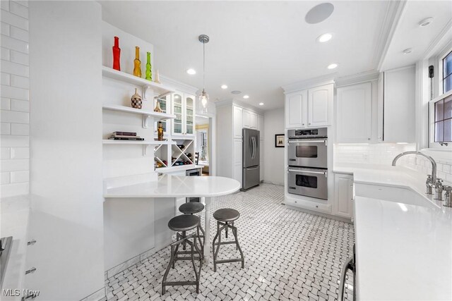 3006 Kingsley Rd, Shaker Heights, OH 44122 - kitchen featuring a breakfast bar, a sink, open shelves, stainless steel appliances, and white cabinets
