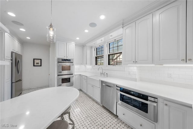 3006 Kingsley Rd, Shaker Heights, OH 44122 - kitchen featuring a sink, decorative backsplash, stainless steel appliances, pendant lighting, and white cabinetry