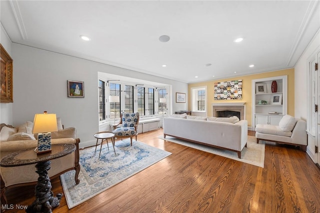 3006 Kingsley Rd, Shaker Heights, OH 44122 - living area featuring built in features, wood finished floors, a fireplace, recessed lighting, and crown molding