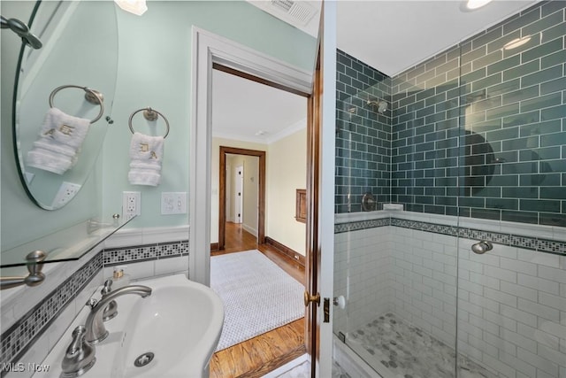 3006 Kingsley Rd, Shaker Heights, OH 44122 - full bathroom with visible vents, crown molding, a stall shower, wood finished floors, and a sink