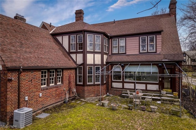 3006 Kingsley Rd, Shaker Heights, OH 44122 - rear view of house with stucco siding, a lawn, cooling unit, brick siding, and a chimney