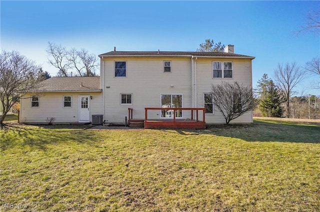 back of property with a chimney, a lawn, a wooden deck, and central AC