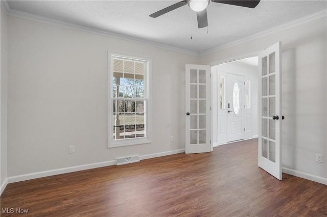 empty room with french doors, visible vents, wood finished floors, and crown molding