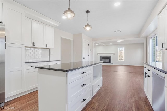 kitchen with decorative light fixtures, backsplash, wood finished floors, and appliances with stainless steel finishes