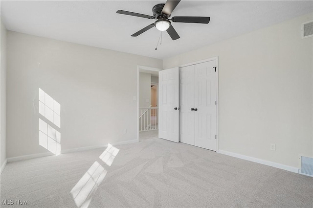 unfurnished bedroom featuring a closet, carpet flooring, visible vents, and baseboards